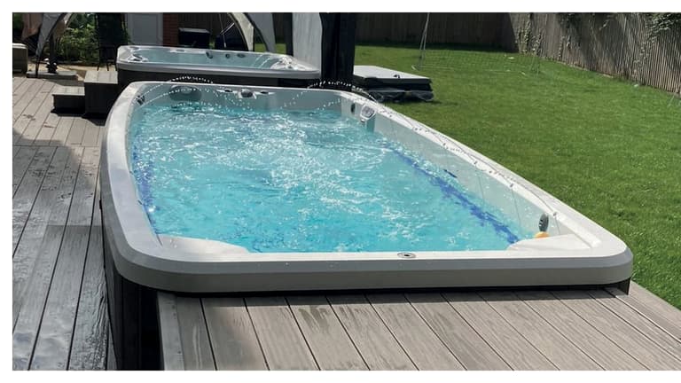 Swim spa i förgrunden och spabad i bakgrunden installerade tillsammans på en trädäck